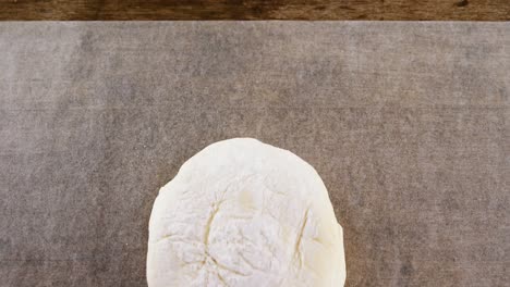 Dough-ball-pressed-on-butter-paper-4k