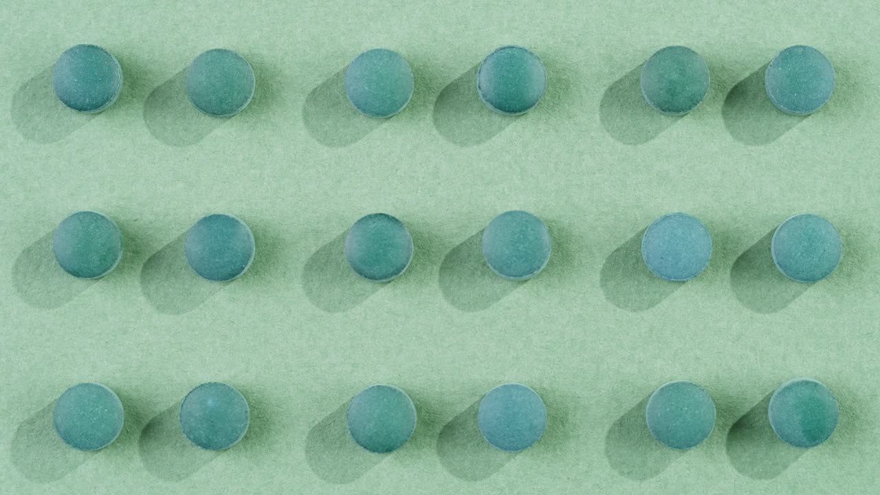 Green mint mentol lollipops, candies, bonbons disappear on purple background. Summer bright texture studio shot for store, supermarket, close up top view. Children favorite sweets made of sugar.