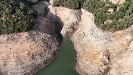 Dry-banks-of-water-reservoir-in-Spain-during-heat-season,-aerial-drone-view