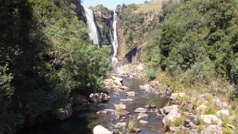 vista aérea siguiendo el arroyo de cascada hacia la pacífica cordillera de drakensberg