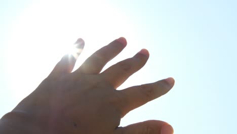 female hand playing in the sun. close upsilhouette of hand against blue sky. freedom concept.