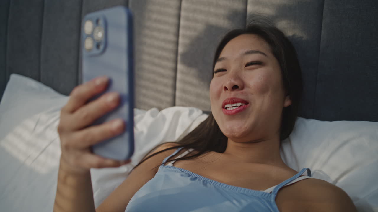 Woman in bed using phone