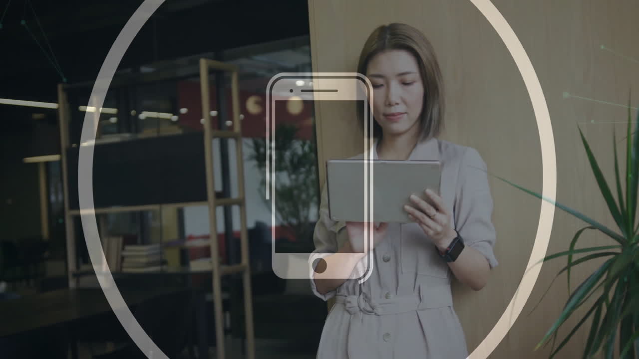 Business professional using tablet in co-working space, showing animated smartphone graphic overlay