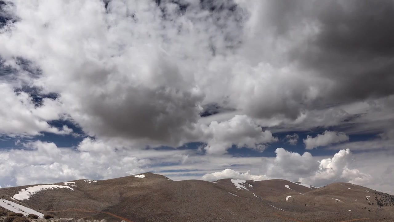 Time-lapse di nuvole che si muovono su cime montuose innevate