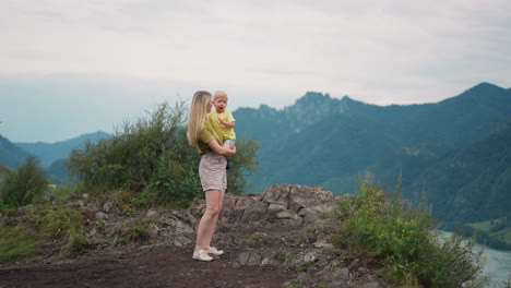 woman prohibits son to suck fingers standing on rocky hill