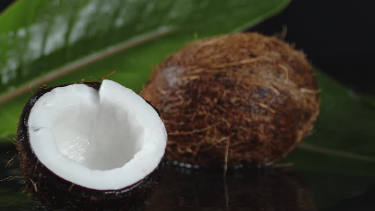 el coco se divide en mitades que caen al agua.