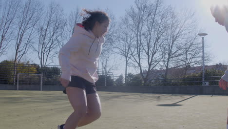 four female friends playing soccer outdoors