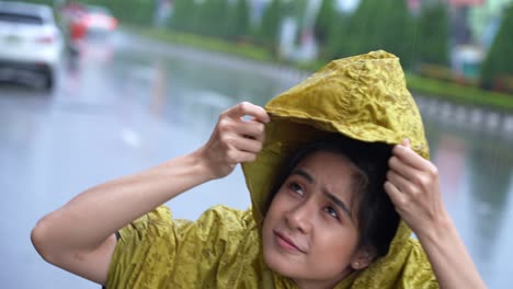 asian girl wear yellow raincoat rushing put on the hoodie, start to rain, rainy season weather climate pouring rain, bad luck get wet while going out for work, rush hour rain, stuck in the rain