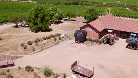 Toma-Aerea-De-Vehiculos-Agricolas-Estacionados-En-Finca,-Cauquenes,-Valle-Del-Maule