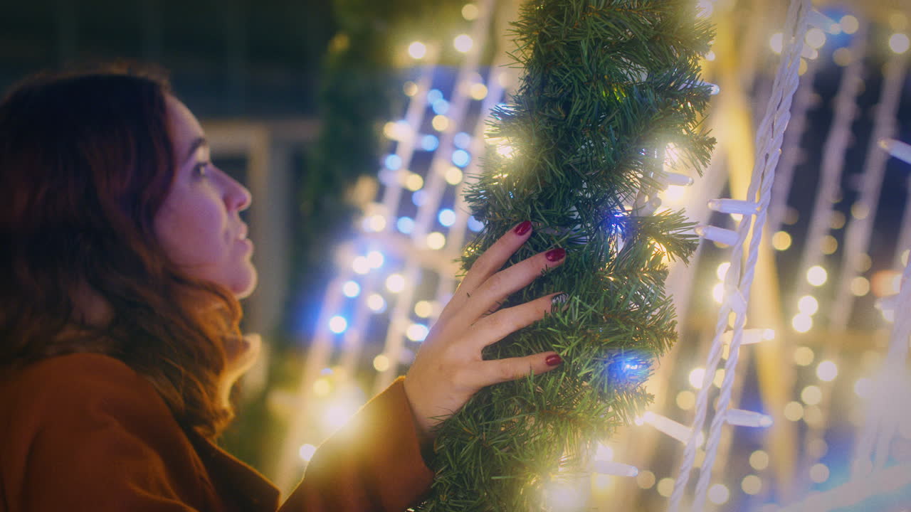 la chica disfruta de las hermosas luces de navidad cerca de la cámara lenta