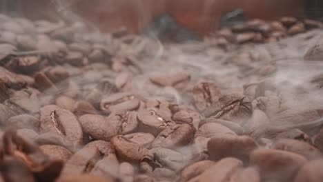 cerca de las semillas de café. los granos de café perfumados son tostados el humo viene de los granos de café.