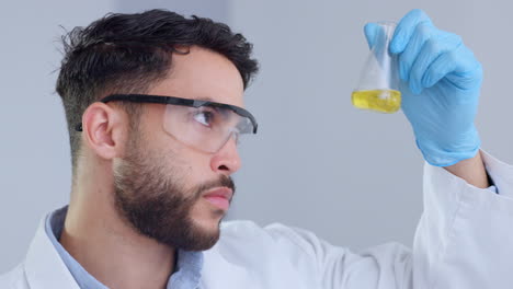 serious male scientist analyzes liquid in a beaker