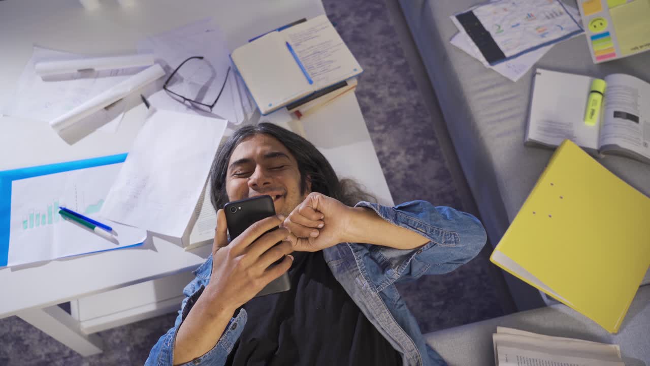 hombre perezoso mirando el teléfono en casa y no haciendo sus deberes.