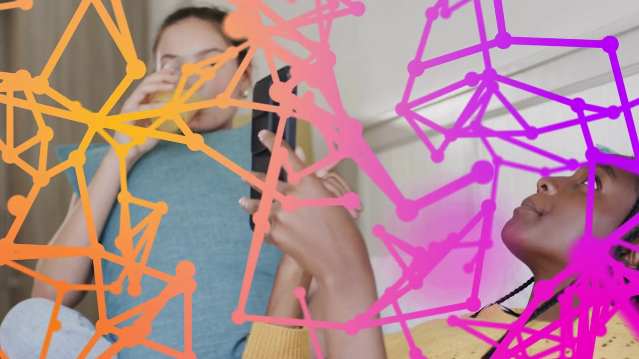 Two teenage girls tapping smartphone on bed, causing polygonal overlay rising fading, showing tech