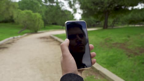 Spiegelbild-Eines-Mannes-Mit-Helmen-Auf-Einem-Mobiltelefon,-Blick-In-Den-Himmel-Und-Dann-Touchscreen
