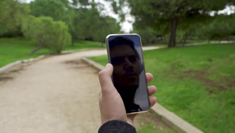 reflection of man with helmets on mobile, look at the sky and then touch screen