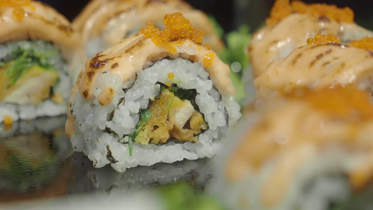 Close-up of Delicious Japanese Sushi Rolls Topped with Sauce and Roe