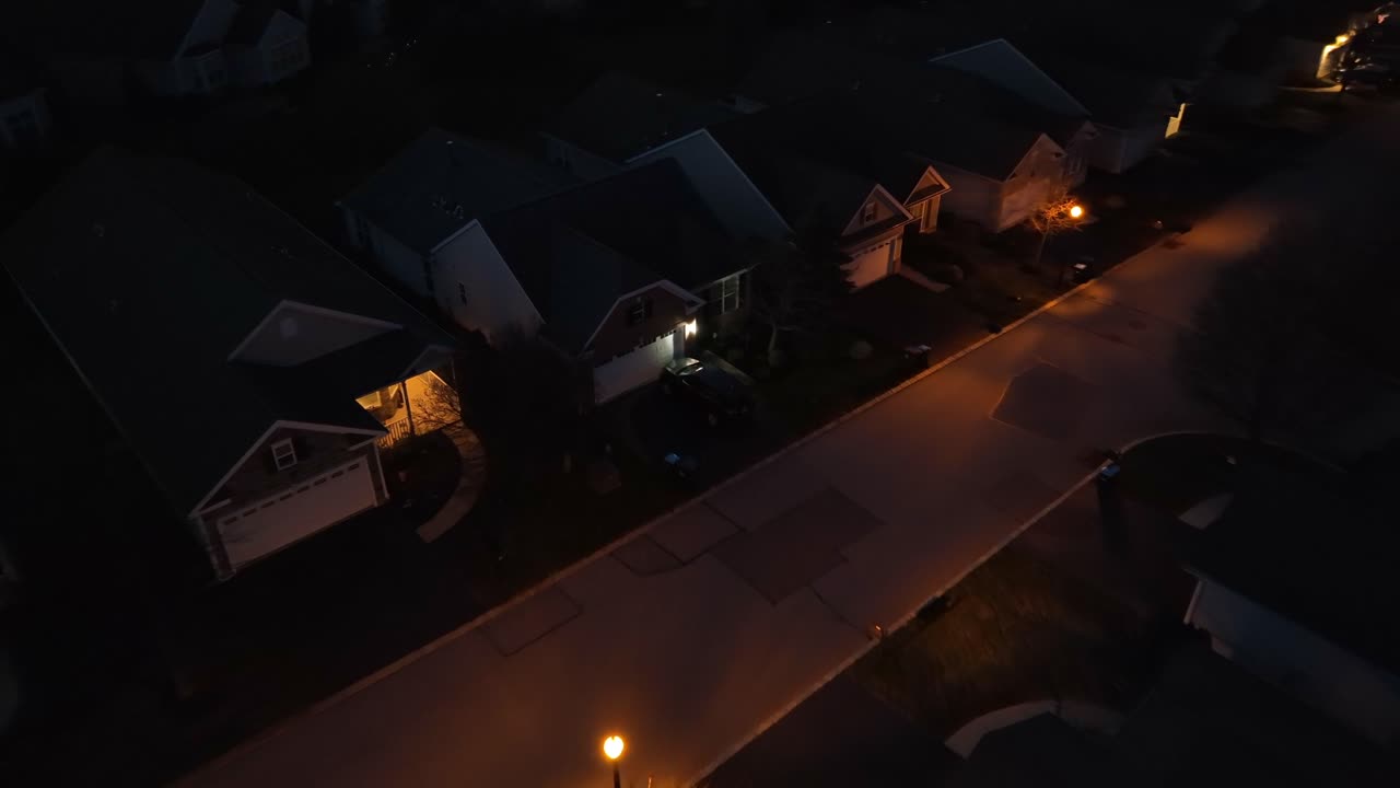 밤에 미국 동네의 차고 앞에 주차하는 차