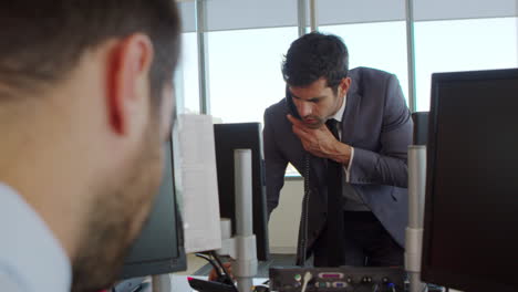 hombre de negocios haciendo una llamada telefónica de pie en el escritorio en la oficina