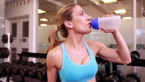 Mujer-Súper-En-Forma-Bebiendo-De-Una-Botella-De-Agua.