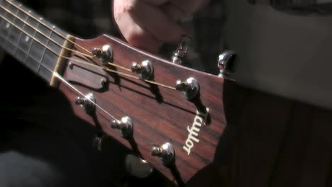 man tunes an old guitar