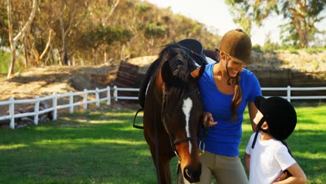 Portrait-of-happy-mother-and-daughter-standing-with-horse-4k