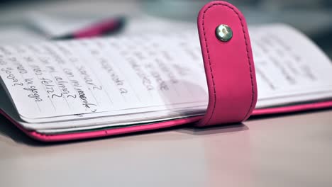 Dolly-shot-over-the-pink-diary-with-notes