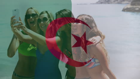 taking selfie with algerian flag animation, women in swimwear on beach