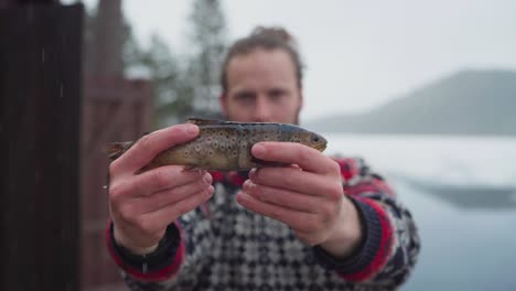 Pescado-De-Trucha-Arco-Iris-Sostenido-Por-Un-Pescador-Durante-La-Pesca-De-Hielo-En-Invierno