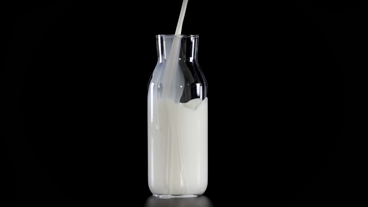 la leche se vierte en botellas de vidrio con pajitas