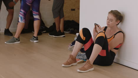 beautiful caucasian woman dancer using smartphone in dance studio texting sharing practice on social media resting after intense workout exercise