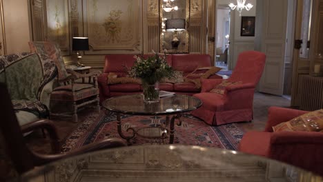 Panning-Down-Shot-Of-A-Beautiful-Living-Room-Onto-A-Mirrored-Table-Revealing-The-Roof