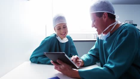 doctor and colleague discussing over digital tablet