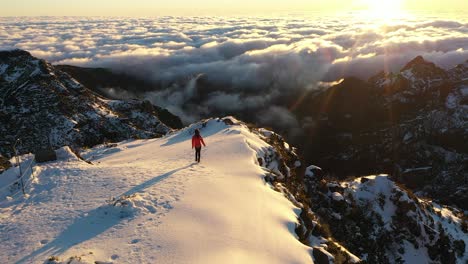 a woman is walking along the edge of the mountain pico ruivo in madeira