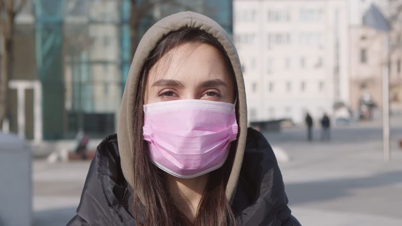 mujer con una máscara rosa en una ciudad