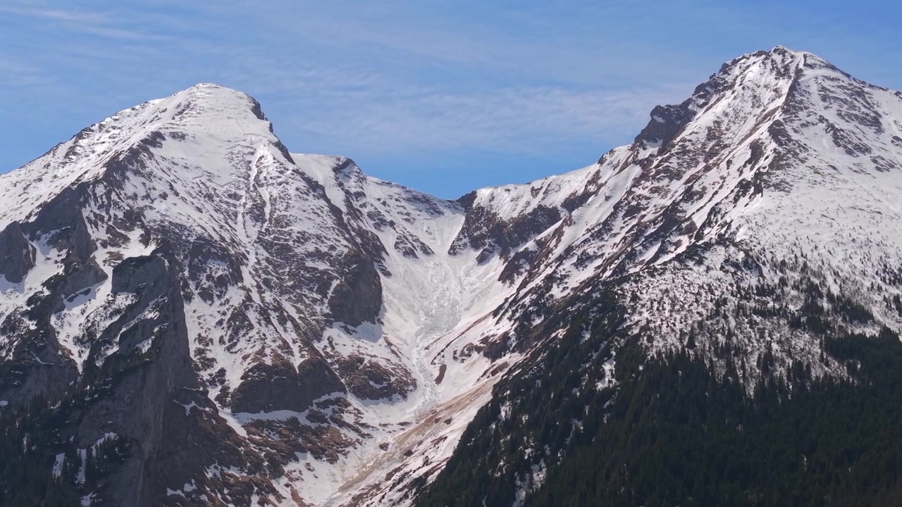 Betagende panoramaudsigt over en smuk bjergdal med sneklædte tinder og stedsegrønne skove i Belianske Tatras i Slovakiet
