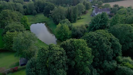 aerial drone view of small lake in lush green forest of brittany in france