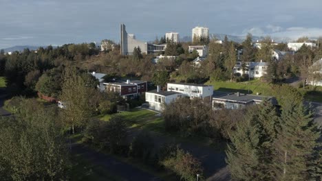 Suburban-modern-homes-in-Iceland-with-golden-hour-sunlight,-aerial