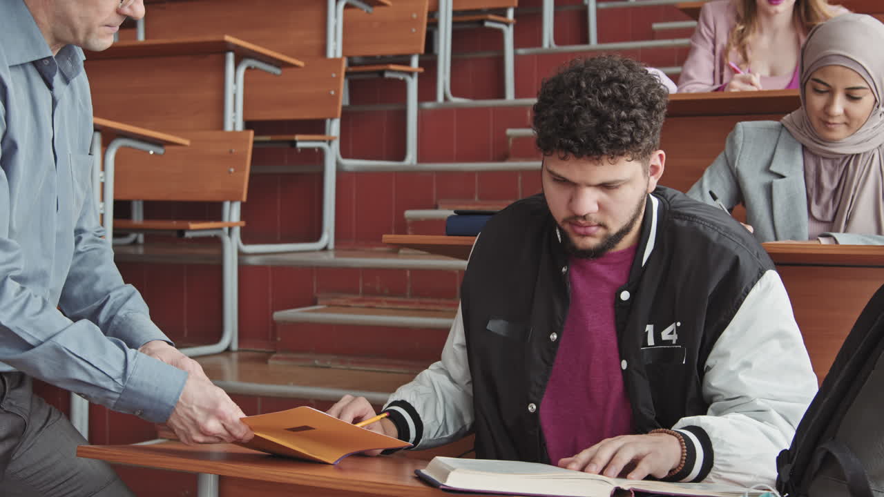 University Professor Helping Male Student during Test