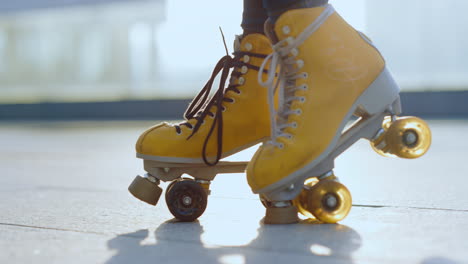 unknown roller skater staying outside. woman feet riding rollerblades outdoor.