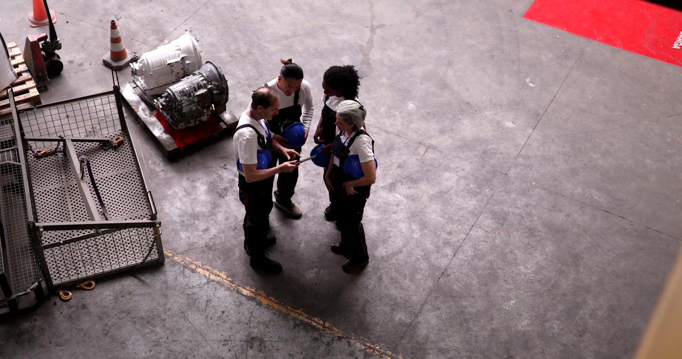 Group of Industrial Workers Discussing Plans in a Warehouse