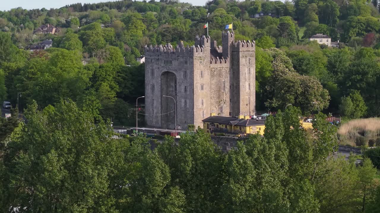 A scenic aerial view of the Bunratty Castle, surrounded by trees and hills in County Clare