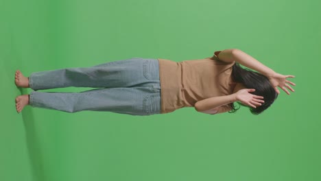 full body of young asian woman victim of violence with bruise on body making hands defending gesture and fearing in the green screen background studio