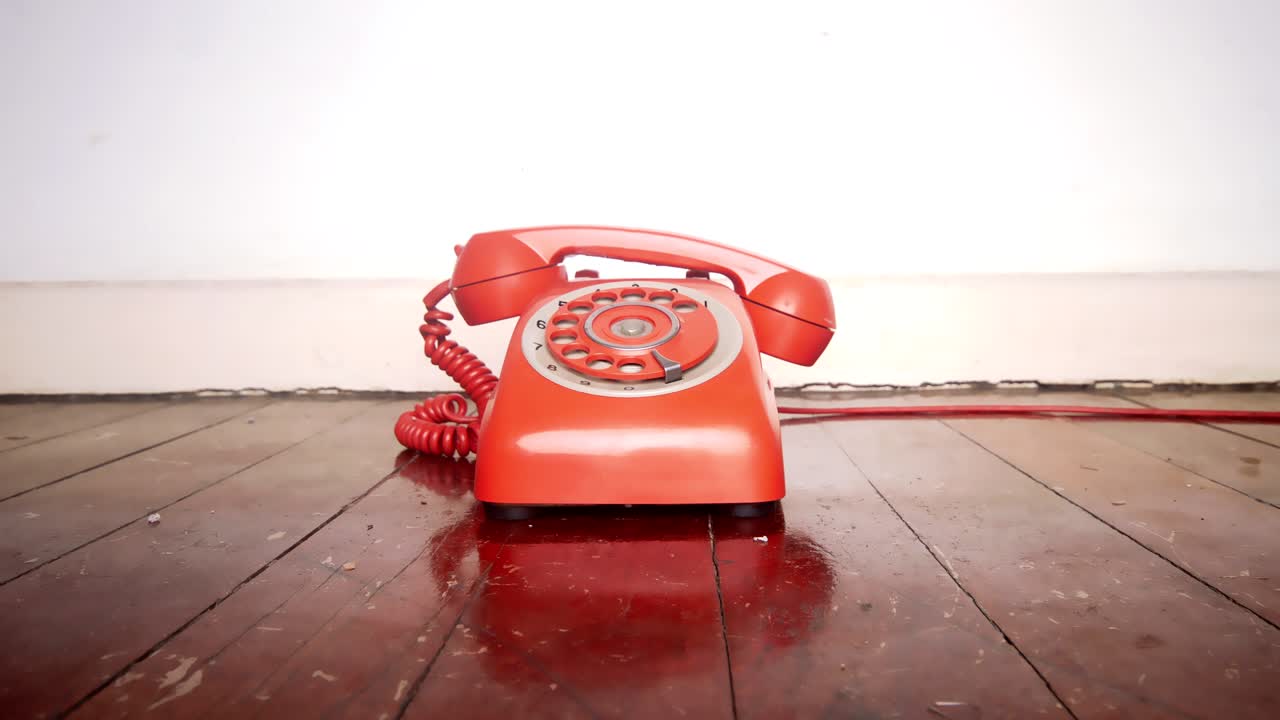 teléfono vintage sonando del gancho en el piso de madera viejo