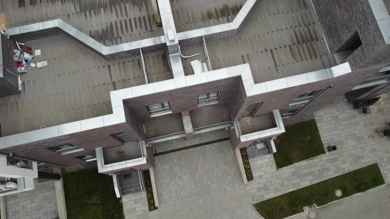 Vista aerea di un drone in volo sopra edifici residenziali, riprese di tetti e architettura.