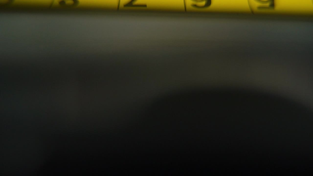 macro video de un medidor amarillo, herramienta de medición, súper primer plano, movimiento lento 120 fps, full hd, inclinación hacia arriba movimiento suave