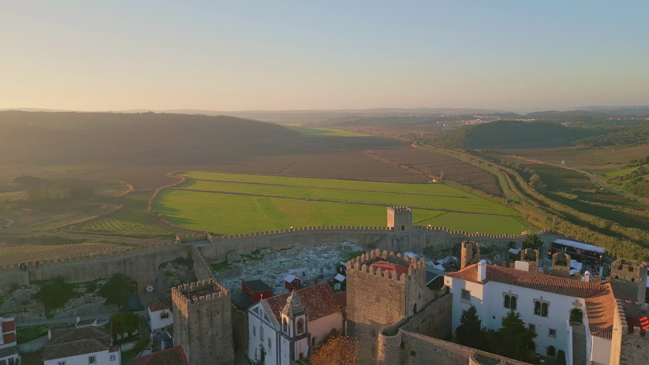 Aerial picturesque green valley stretching behind town with medieval castle.