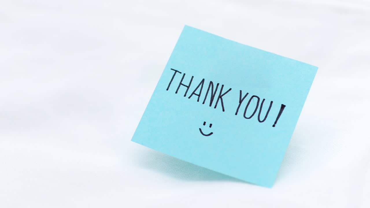 A close-up of a cheerful thank you note highlighting appreciation in a simple minimalist home office.