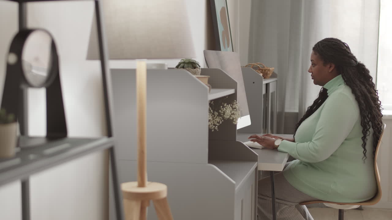Young African Woman Typing on PC Keyboard