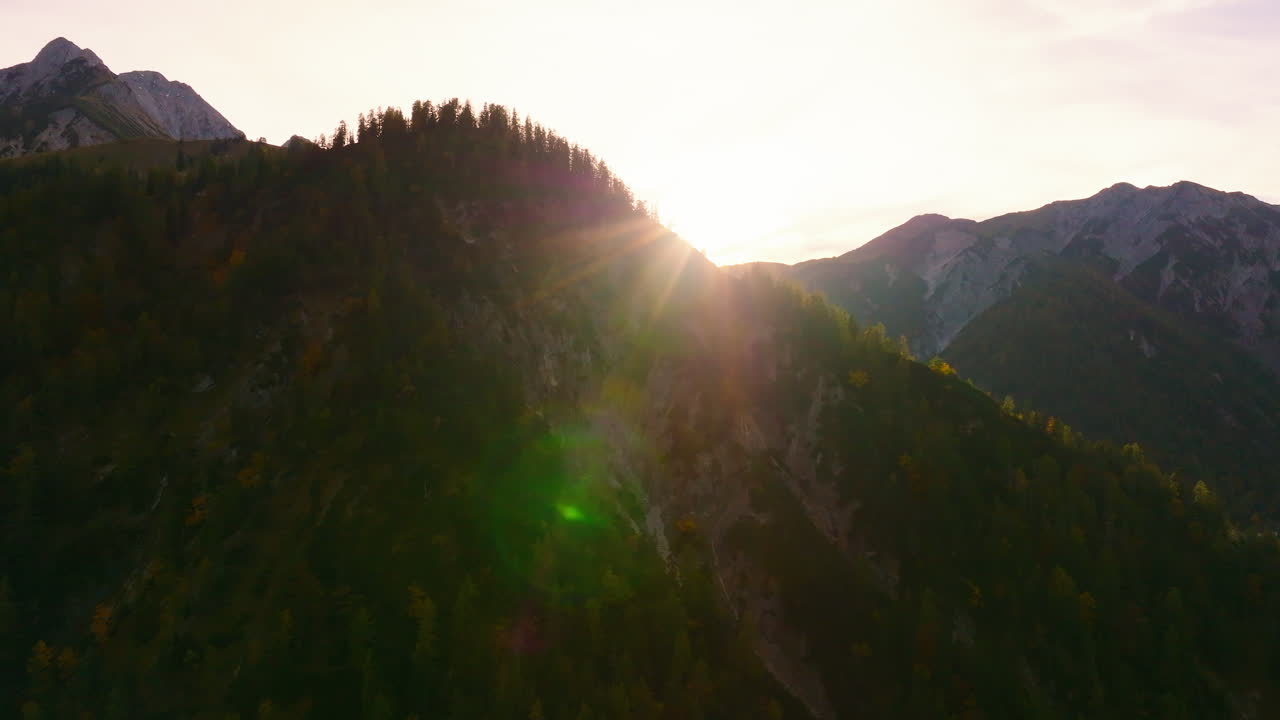 록키 티롤 삼림 알프스 산맥 실루엣 봉우리가 오른쪽 궤도를 도는 조감도 뒤에서 떠오르는 황금빛 태양광선